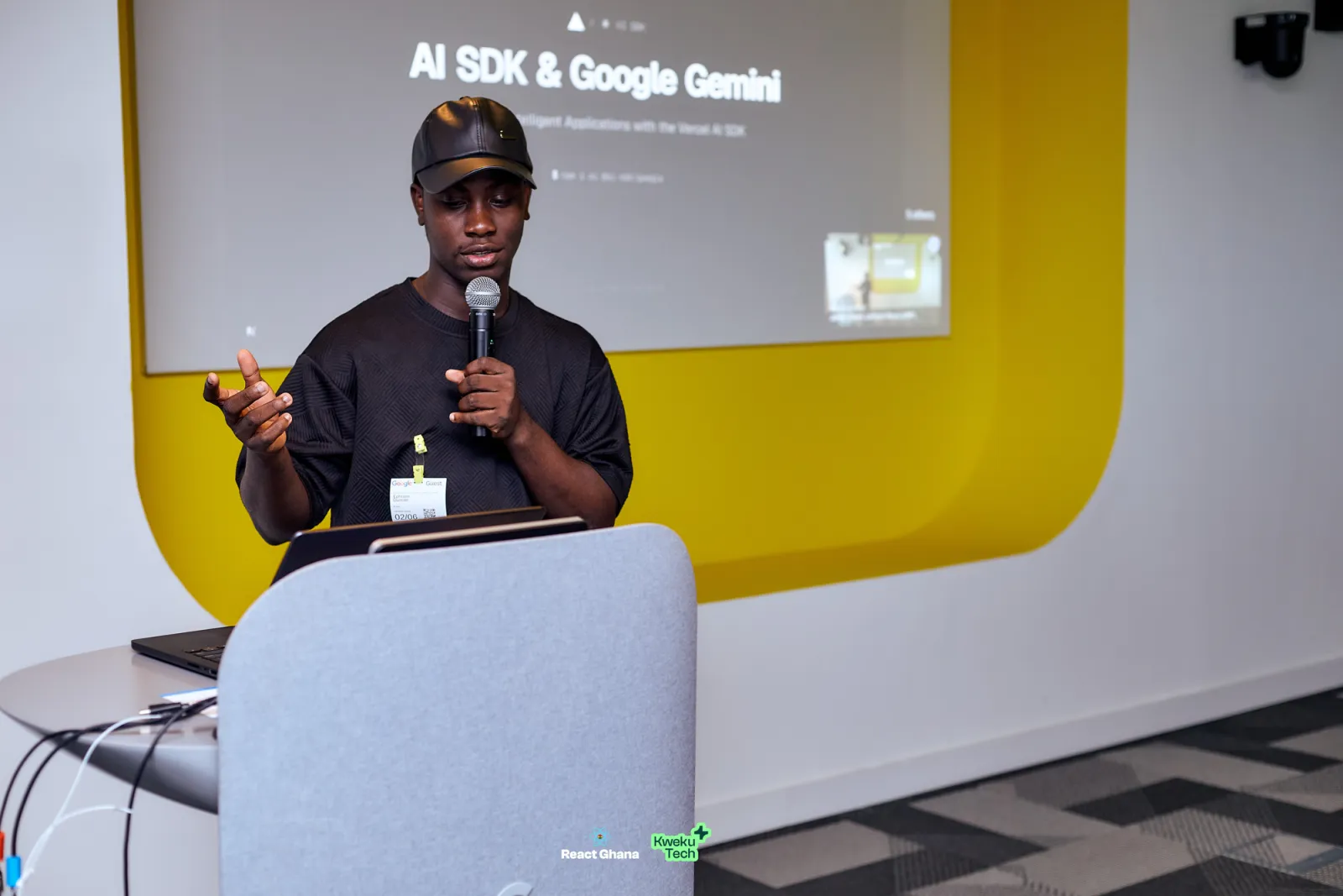 Ephraim Atta-Duncan of Telemetry speaking at a lectern, a slide titled AI SDK & Google Gemini on the screen behind